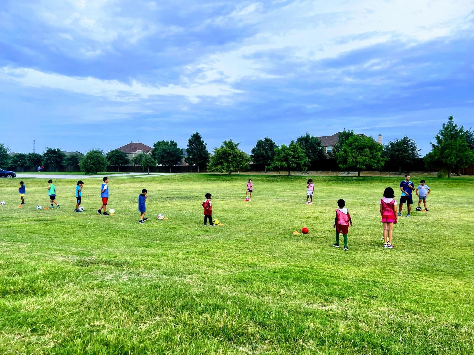 LetsAimIt coach huddled with a group of young football players before training