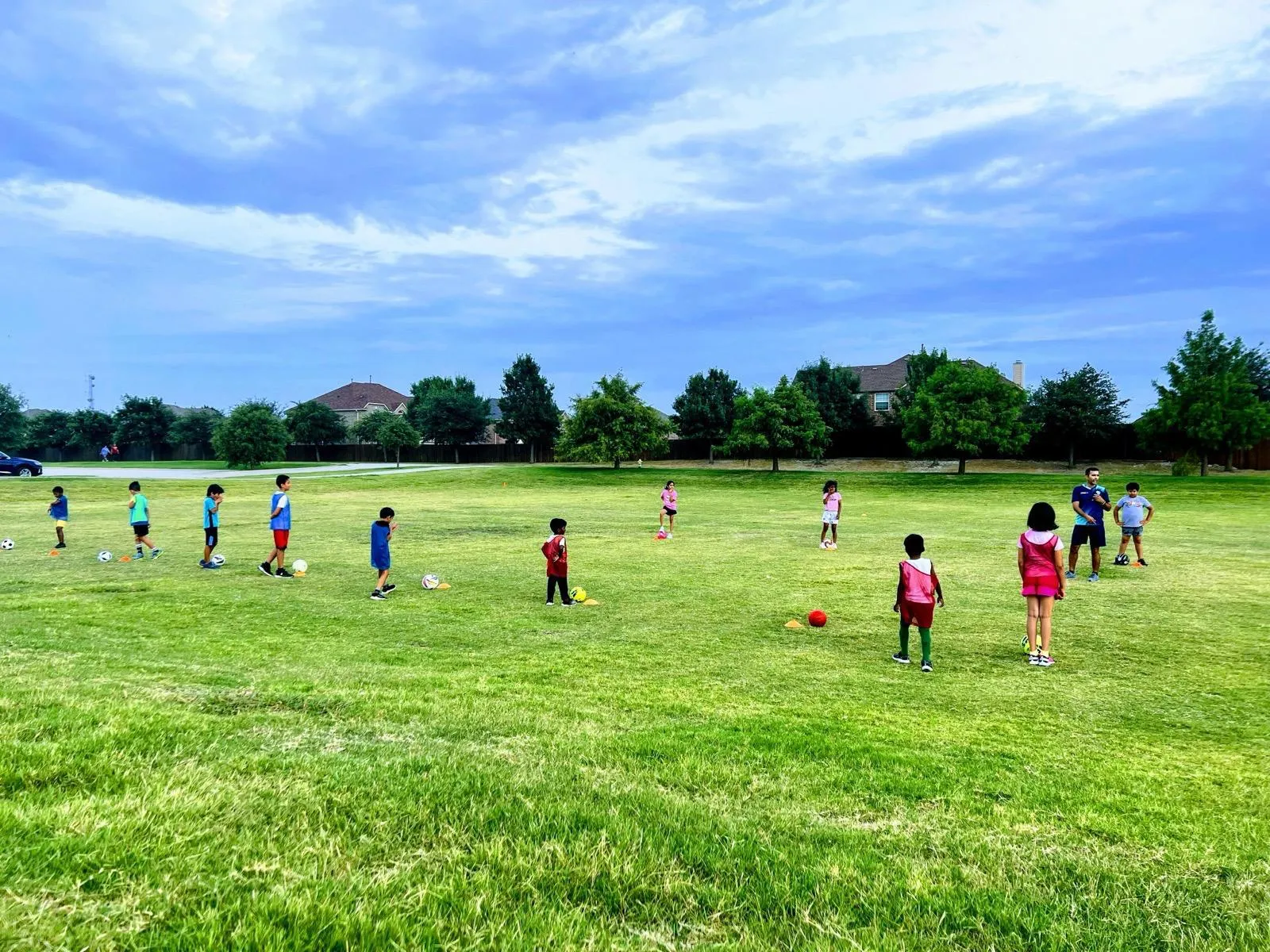 LetsAimIt coach huddled with a group of young football players before training